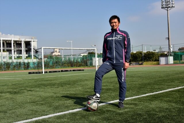 駒澤大学玉川キャンパスのグラウンドにて。総合教育研究部の講師として教壇に立ちながら、サッカー部のコーチとして学生たちの指導にあたる岩本先生。